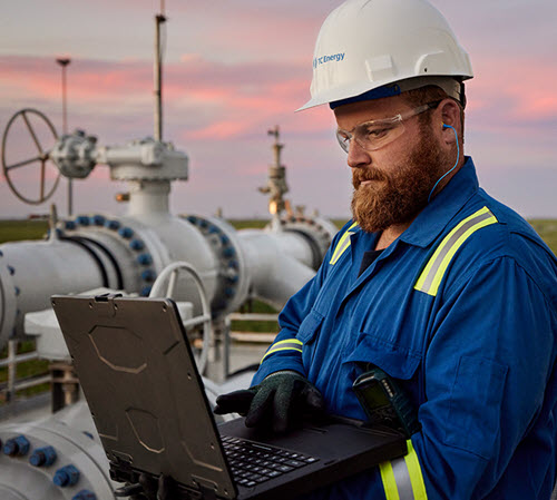 Worker in a hardhat on a laptop